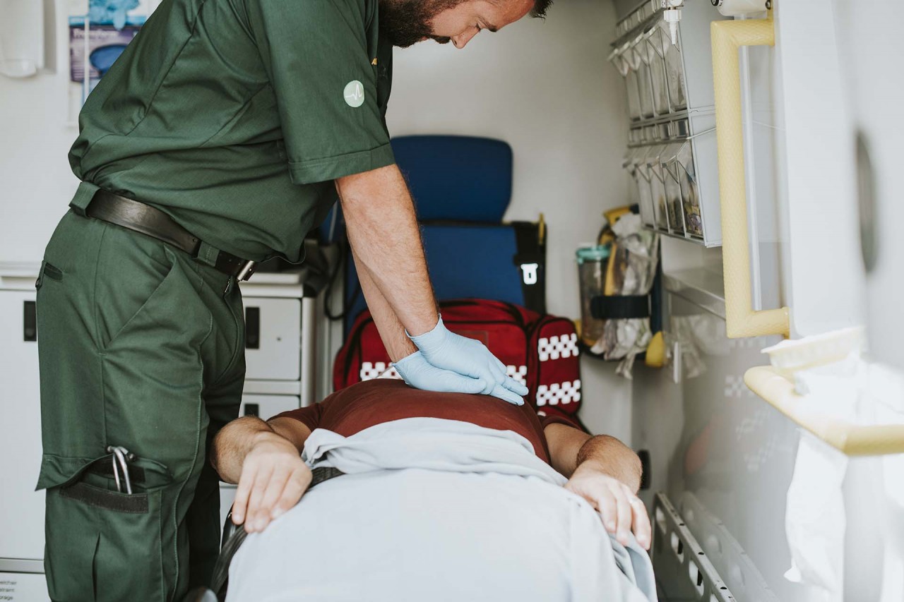 paramedic-resuscitating-a-patient-in-an-ambulance-TW3J9DB